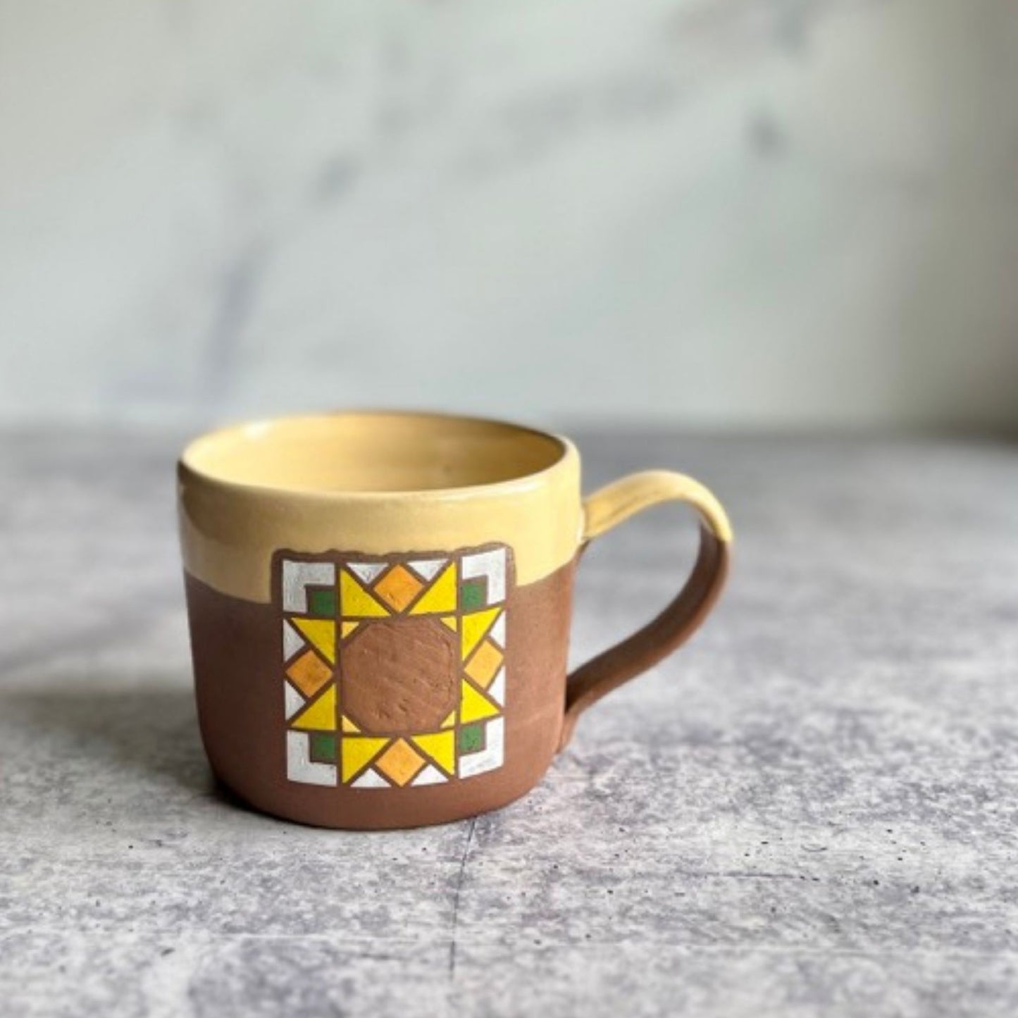 Sunflower barn quilt ceramic mug detail - artisan crafted pottery coffee cup.