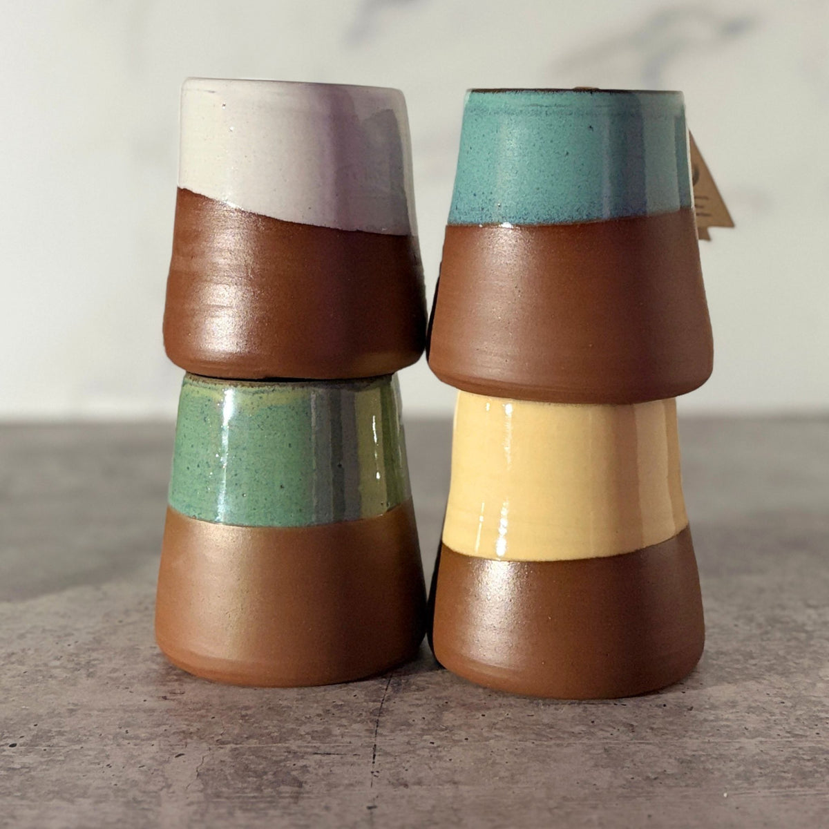 4 cone shaped bud vases in white, turquoise, green and yellow,  stacked