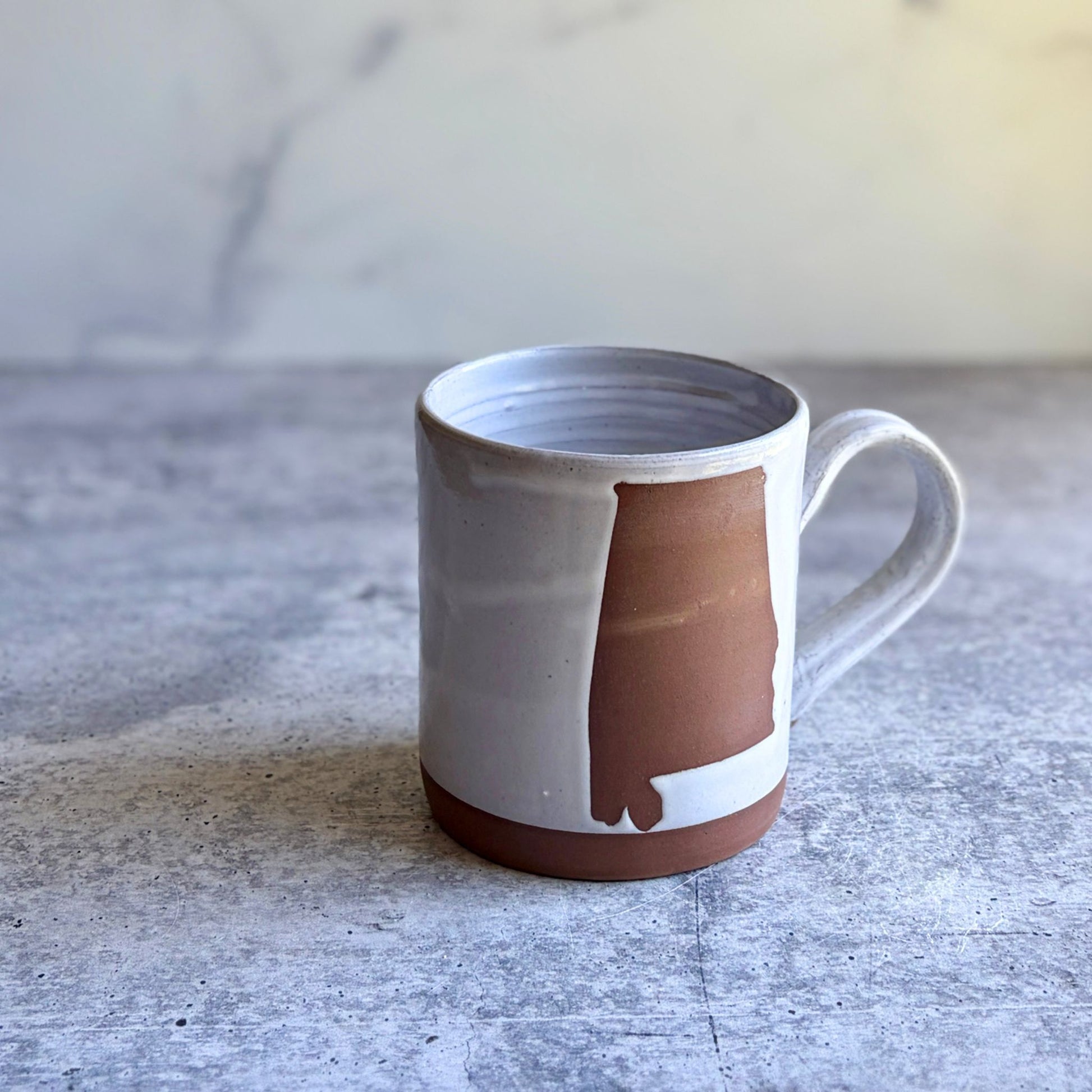 14-16 oz Alabama stoneware mug showing wax resist state shape and white glaze, handmade by ceramic artist Heather Richardson at End of the Road Farm Studio