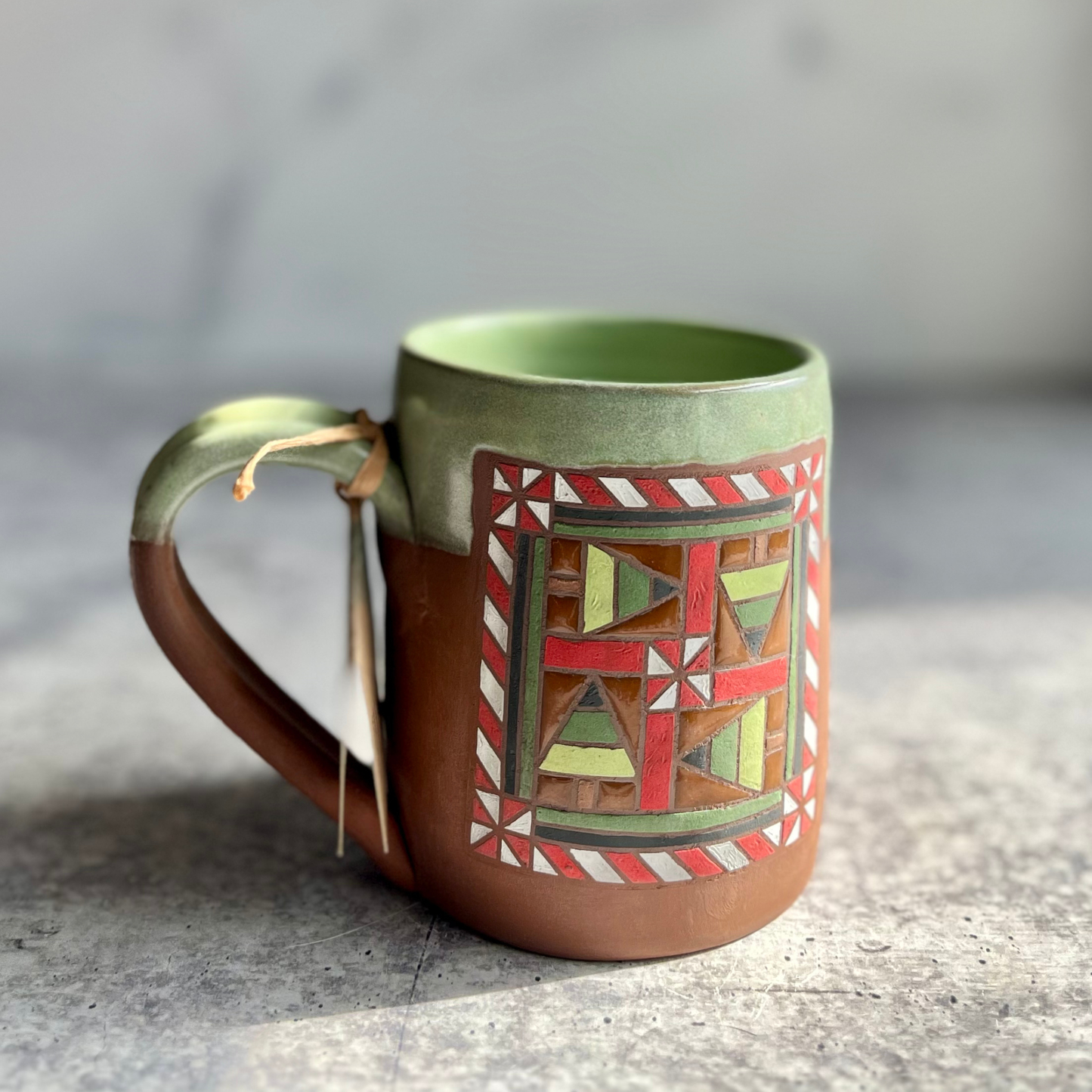 Ceramic mug with geometric pattern on a gray surface