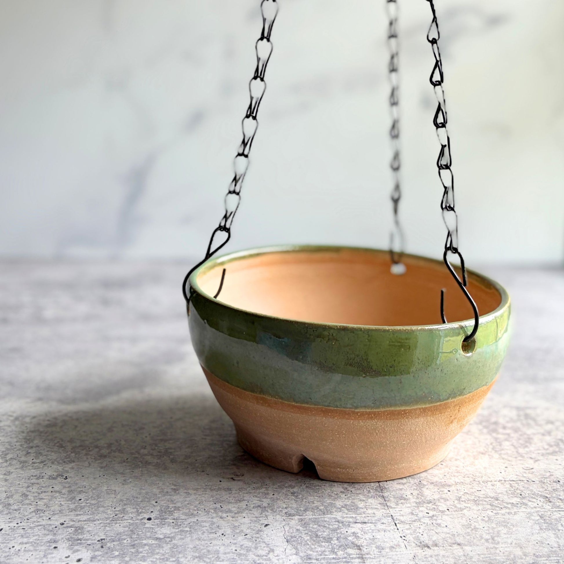 Handmade earthy green stoneware hanging planter with removable chain, wheel-thrown in Ethelsville Alabama