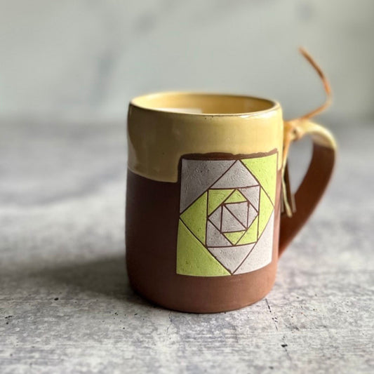 Ceramic mug with geometric design on a textured surface
