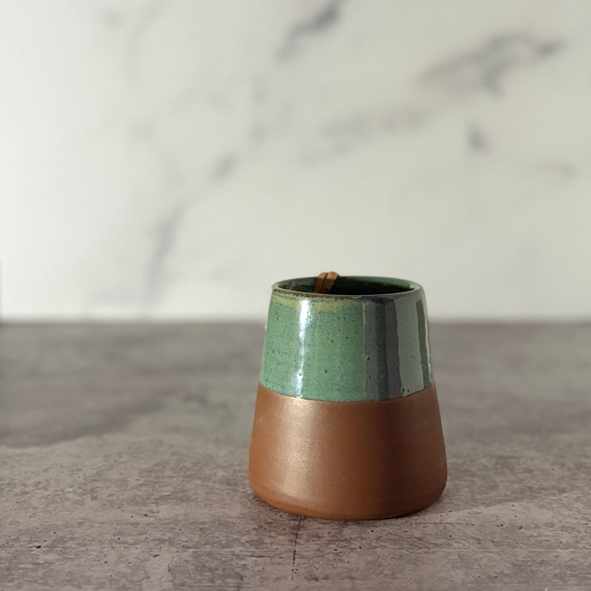 Cone shaped bud vase. Green glaze partially down outside showing chocolate clay.