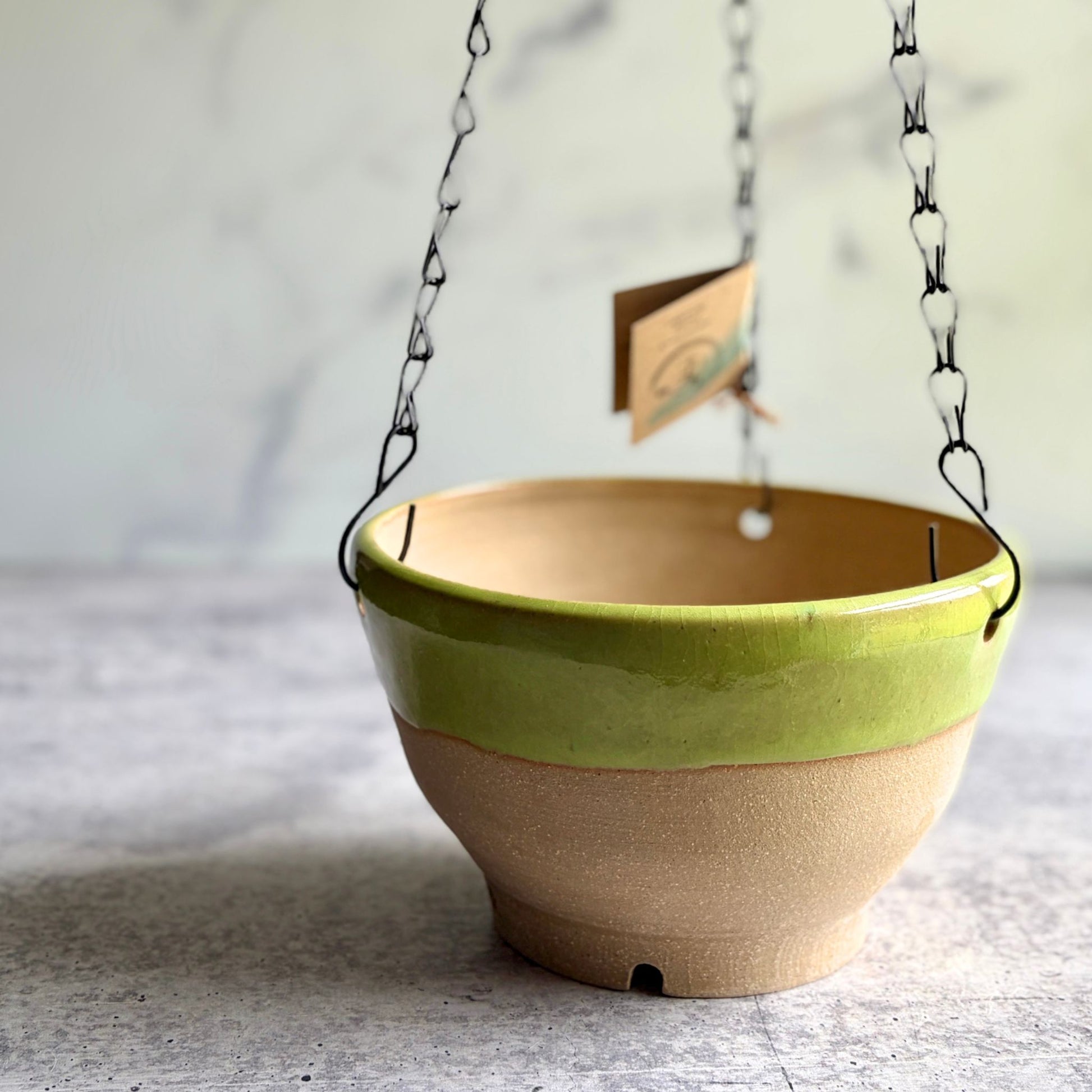 Handmade lime green stoneware hanging planter, wheel-thrown in Alabama, 6¼ inch round ceramic pot with removable chain and unglazed clay base