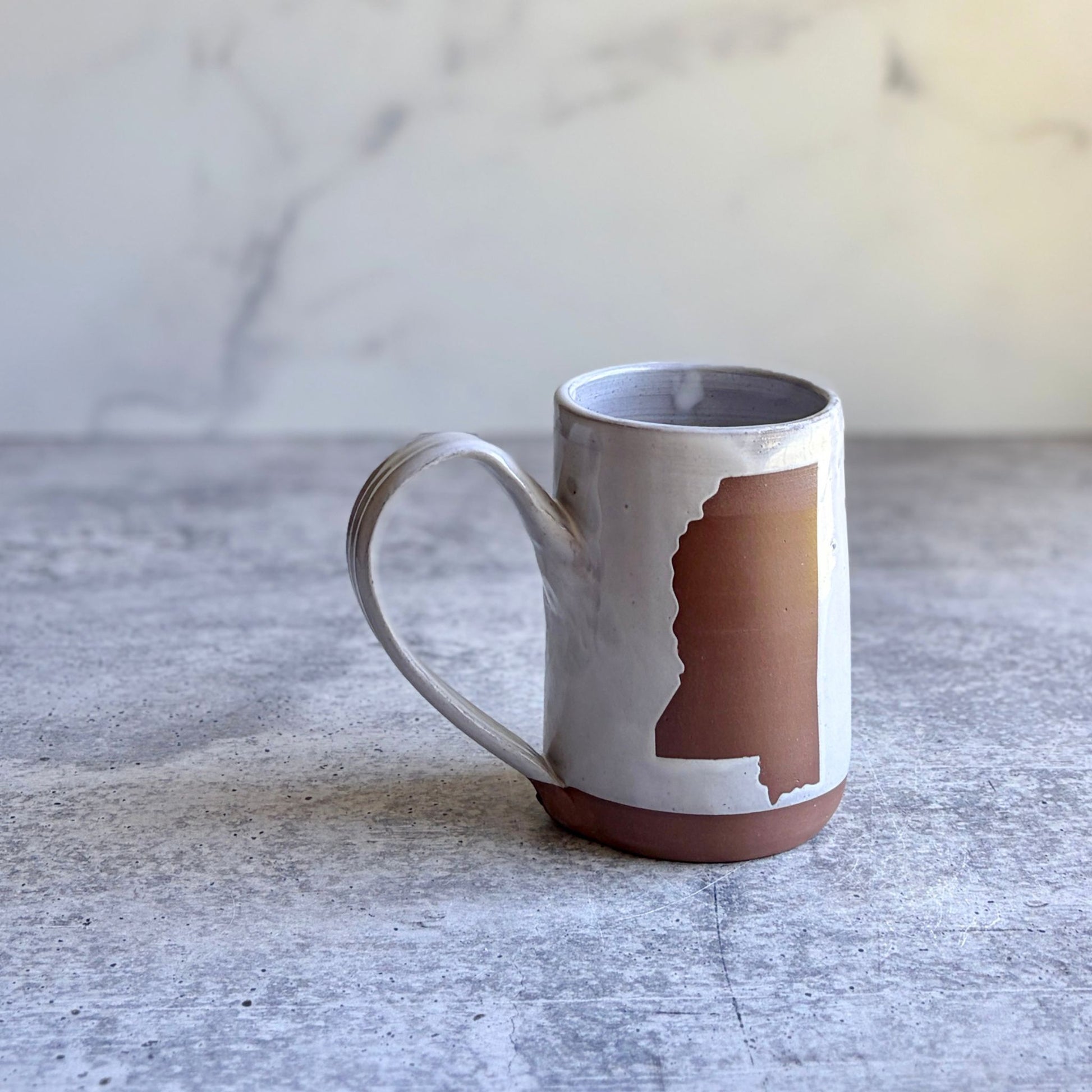 11-13 oz Mississippi stoneware mug showing wax resist state shape and white glaze, handmade by ceramic artist Heather Richardson at End of the Road Farm Studio