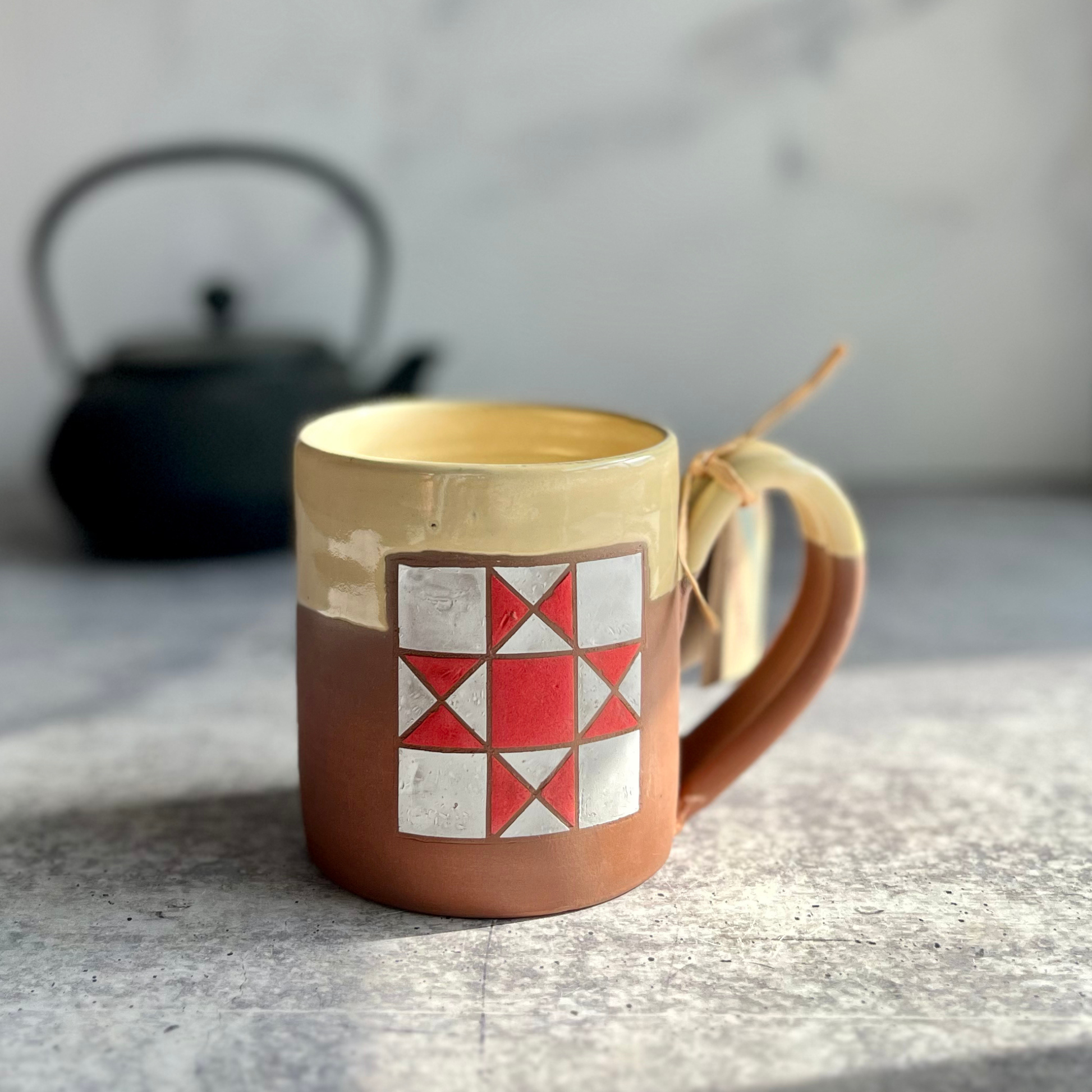 Ceramic mug with geometric design on a textured surface