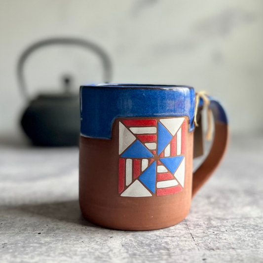 Ceramic mug with geometric design on a textured surface