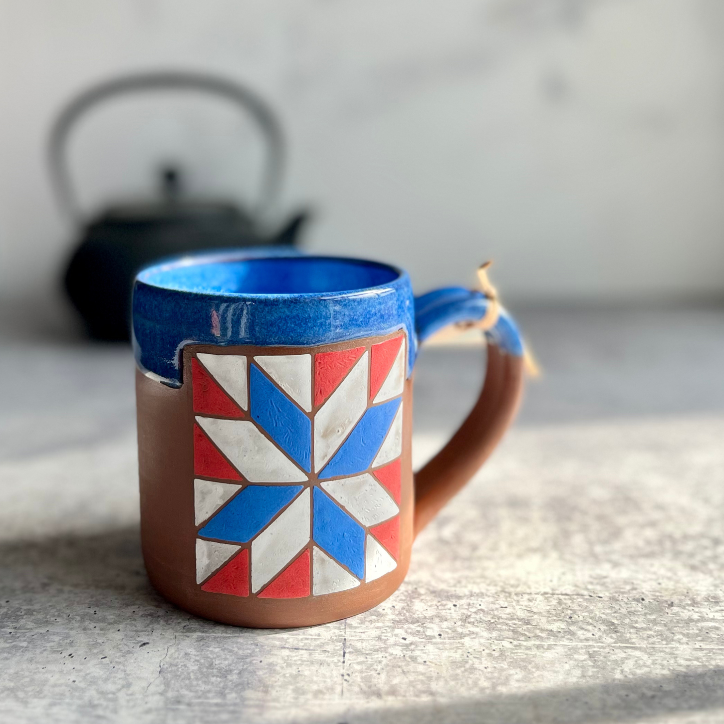 Ceramic mug with geometric design on a gray surface