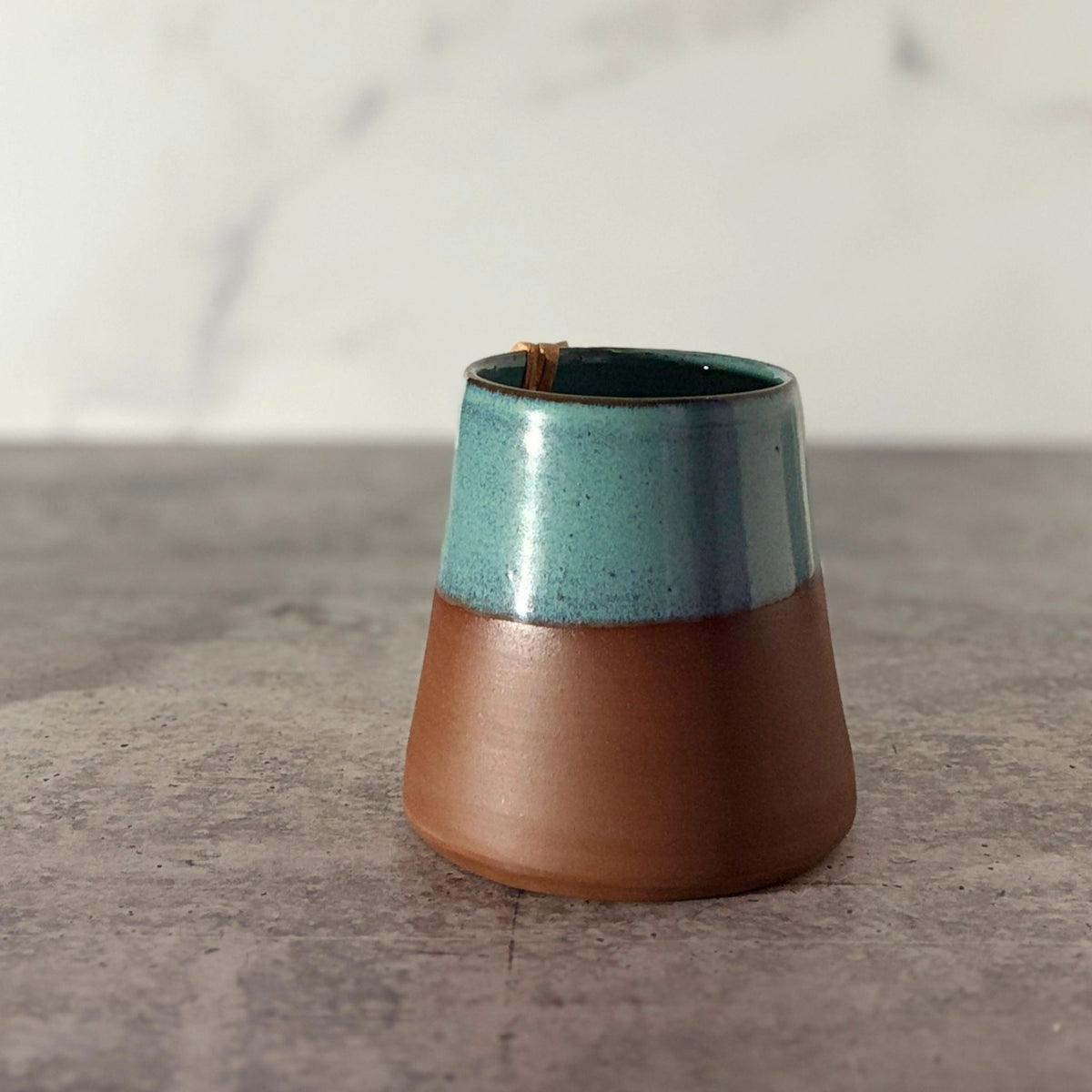 Cone shaped bud vase. Turquoise glaze partially down outside showing chocolate clay.