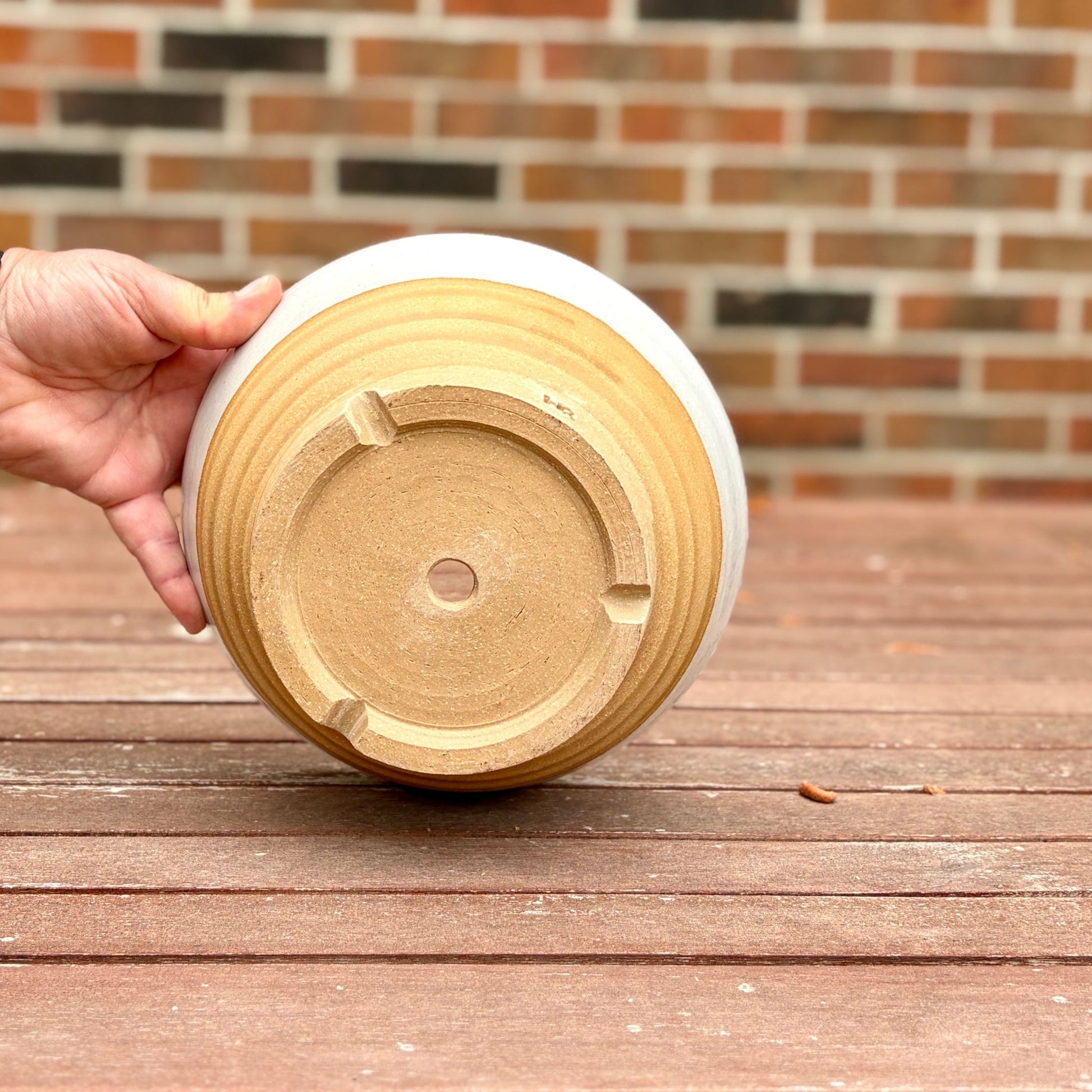 Bottom of handmade white stoneware planter showing drainage hole, wheel-thrown at End of the Road Farm Studio Alabama