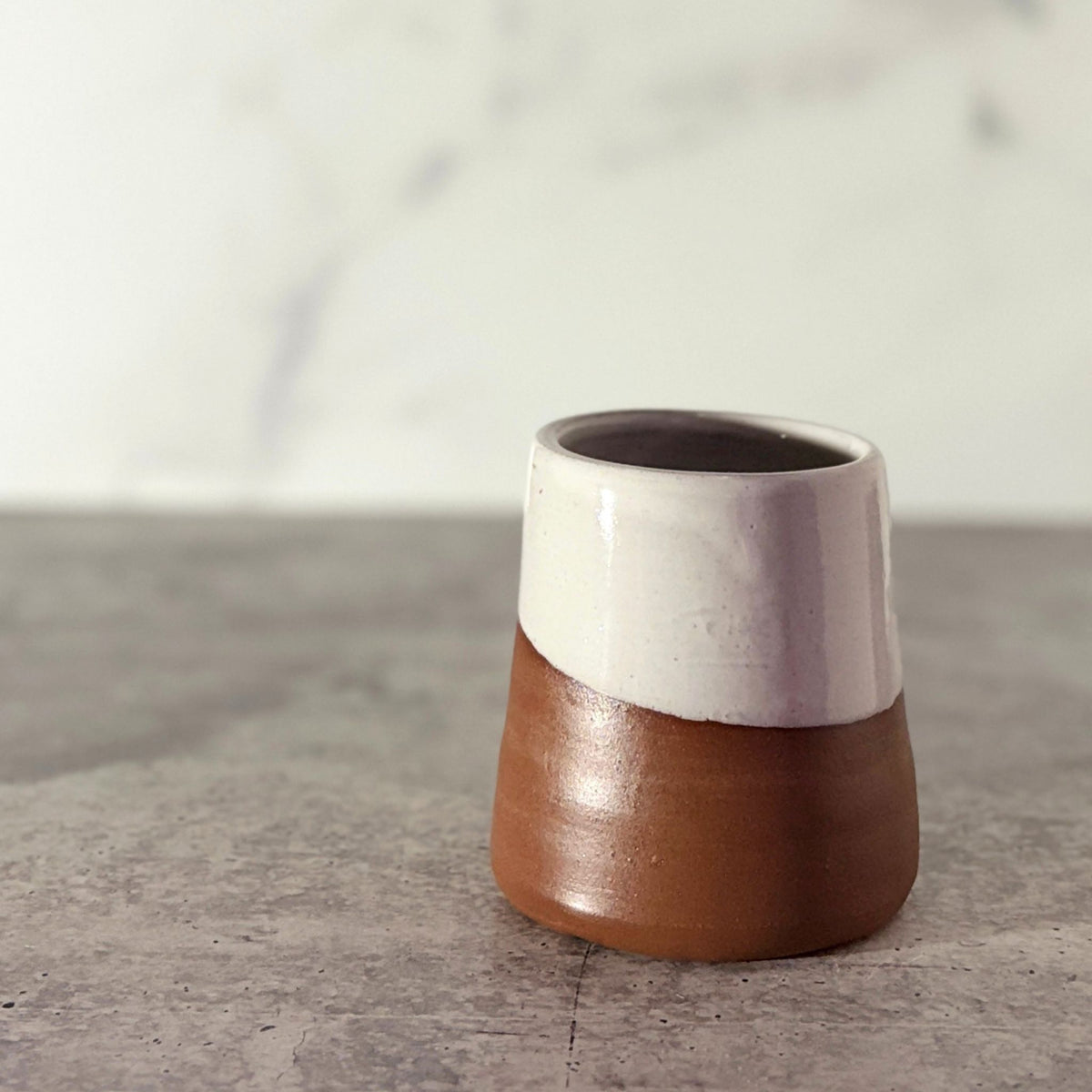 Cone shaped bud vase. White glaze partially down outside showing chocolate clay.